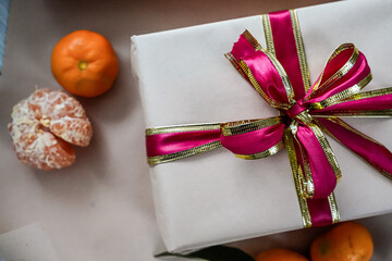 Close-Up of Beige Gift Box with Red Ribbon and Two Tangerines