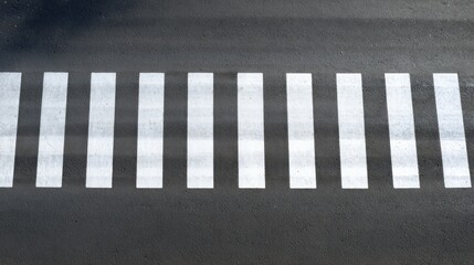 Overhead view of white pedestrian crossing stripes on dark asphalt road surface