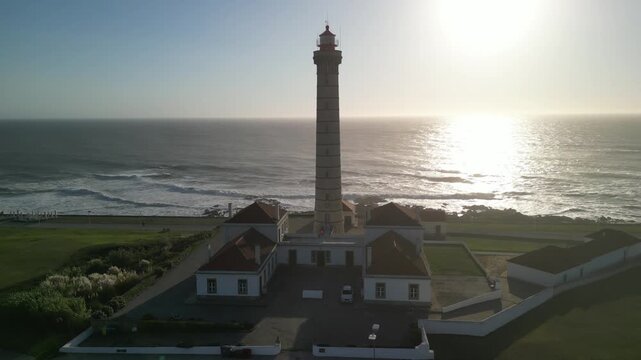 Aerial view of the impressive Farol da Boa Nova lighthouse by the sea, its tall structure contrasting with the adjacent buildings, Leca da Palmeira, Porto District, Portugal.