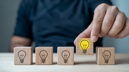 Bright idea is chosen from a group with hand selecting the best option for business success and innovation, a fresh concept for creative solutions