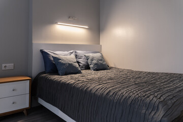 A dim light is turned on above the large double bed. The bedroom is dim and relaxing. There are...