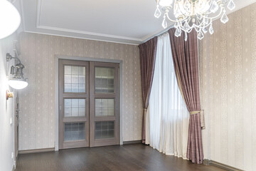 elegant empty room with wooden doors, wooden brown floors, wallpaper and retro lamps on the wall,...