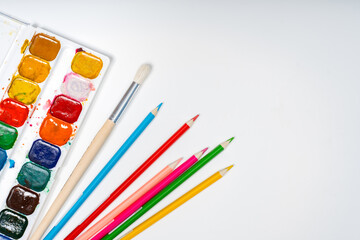 Naklejka premium Stationery on a white background with a place for text, colored cardboard, paints, figures made of plasticine, the concept of a school, kindergarten and DIY