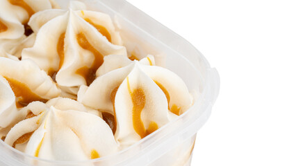 Ice cream with vanilla-caramel flavor in a plastic container. Frozen dessert in a tub, creamy texture.