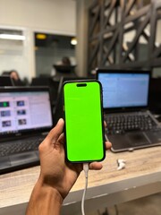 Screen in Modern Office Workspace with Laptops, Charging Cable, Wooden Desk, and Blurred Background Showing Professional Work Environment for Technology