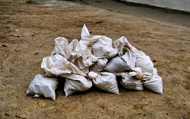 Sacs de gravats sur le sol.