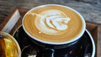 Latte art creation into a black cup.