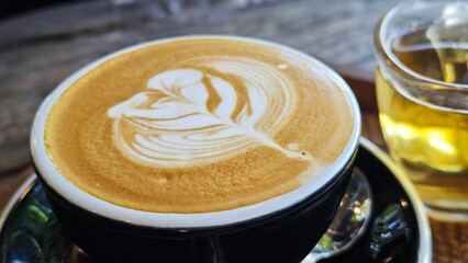 Latte art creation into a black cup.