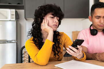 Relaxed friends scrolling phones during everyday home routine