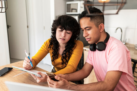 Latino friends combining notes and mobile search in adaptive lifestyle