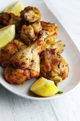 Roasted chicken drumsticks legs on white plate