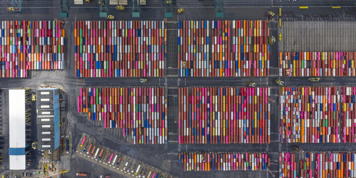 Aerial view of a vibrant tapestry of stacked shipping containers in a logistic port, creating a mesmerizing pattern of colors and lines, Antwerp, Vlaanderen, Belgium.
