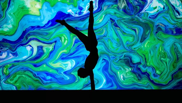 Balancing silhouette acrobat in leotard holding one-arm handstand on stage, with marbled projection - Powered by Adobe