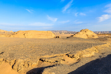 Expansive view of the arid yardang landform and gobi desert with unique geological rock formations in Xinjiang, China.