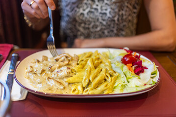 Woman Eating Creamy Pasta Dish