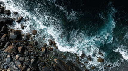 aerial view of rocky seashore with waves and foam
