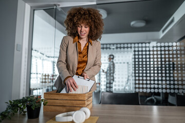Businesswoman packing personal items leaving office workspace