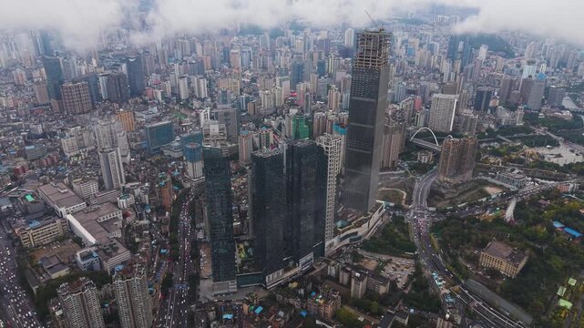 Pull out aerial shot of Guiyang, Guizhou Province, showcasing dense urban neighborhoods, modern skyscrapers, and a sprawling cityscape captured in UHD. China