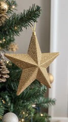 Sparkling gold star ornament hanging from a Christmas tree .