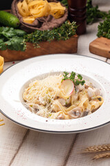 Creamy pasta with tender chicken, mushrooms and grated cheese served on a white plate with rustic elements