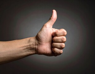 A close-up of a human hand giving a thumbs up gesture against a neutral gray background in a studio setting