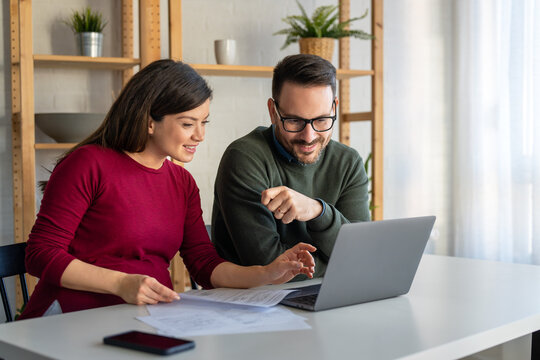 Happy businesspeople laughing while collaborating on a new project in an office.