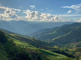 Fototapeta premium Layers of green mountains, sun rays, cloudscape, landscape meadows.