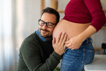 Man in love hugs his pregnant wife, they are waiting together for the baby's arrival. Love, family