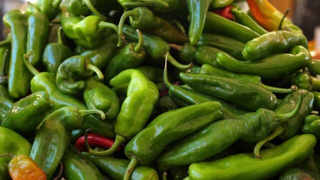 Fresh green friggitelli peppers arranged at a lively Italian market known for ri