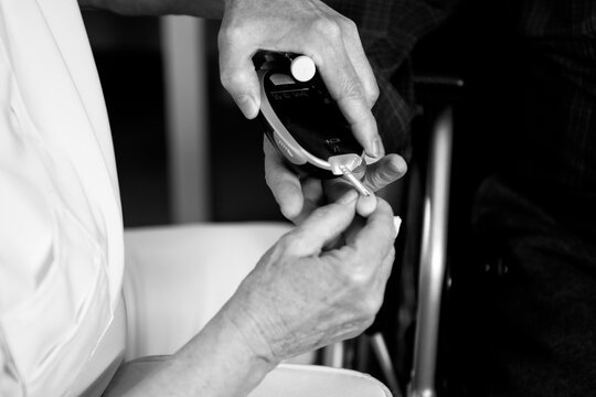 Doctor performing blood sugar test and injecting insulin for diabetes patient - Powered by Adobe