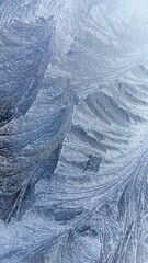 Close-up of blue and white frost pattern on glass: natural winter texture for seasonal design, printed materials, backgrounds, postcards, eco-content, social media, and decorative projects.