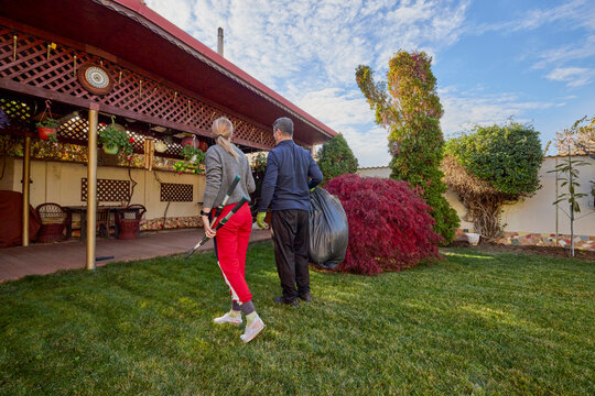 A middle-aged man and his wife work in the garden and do various maintenance activities.