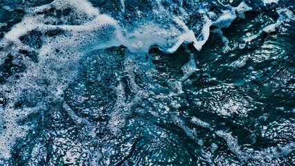 Abstract water surface background of deep blue sea with foam and waves