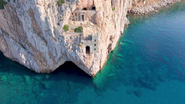  castle nestled on vertical cliffs above serene mediterranean coves near italy. Porto Flavia. 