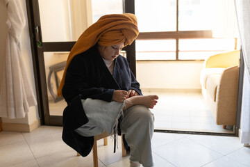 Woman at home self-caring her foot