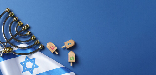 Menorah, Israel flag, dreidel set on blue table. Traditional Jewish holiday celebration. Hanukkah greeting card concept
