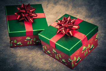 Christmas gift box with red bow on dark background. Toned.