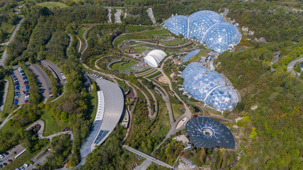 Aerial view of the iconic biomes of the Eden Project, nestled amidst lush greenery, with its futuristic architecture contrasting against the natural landscape, Eden Project, Cornwall, United Kingdom.