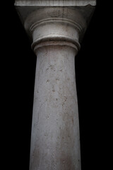 Ancient really stone neoclassical column against black background. Aged stone texture.