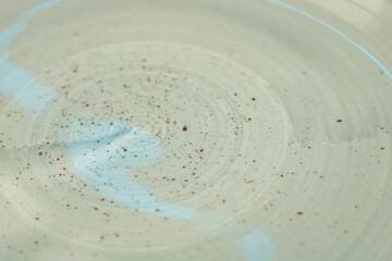 Beige speckled plate texture with blue highlight, background image with focus on background