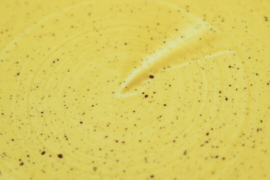 Yellow speckled plate, close-up shot with enamel ceramic texture