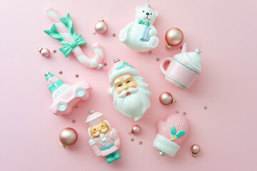 Set of pastel Christmas ornaments on a pink backdrop. Flat lay, top view.