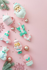 Vertical holiday flat lay composition with pastel Christmas decorations scattered on light pink background. Cute, shabby chic style.