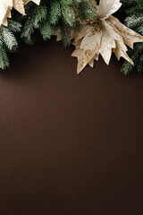 Vertical elegant Christmas background with frosted pine and gold glitter poinsettia along the top edge
