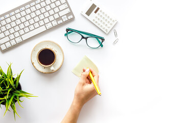 Home office workspace with computer keyboard and cup of coffee on white background, top view....