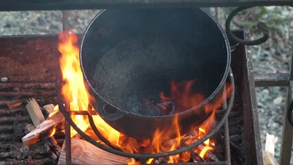 Cast Iron Pot, Open Fire, Heating, cooking pot over flames outdoors, traditional food preparation
