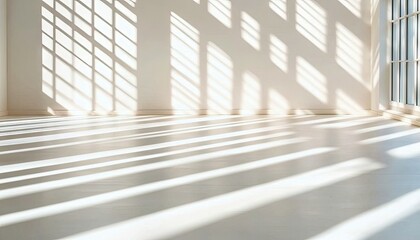 Obraz premium An empty, bright white room with a large window, illuminated by strong sunlight that casts geometric shadows across the floor and wall, creating a serene and ai