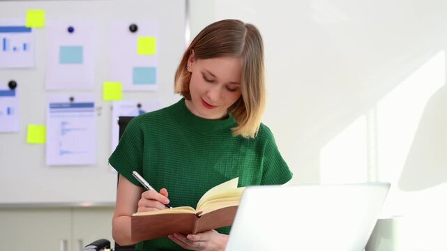 Confident business expert attractive smiling young woman holding digital tablet  on desk in creative office.