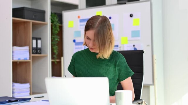 Confident business expert attractive smiling young woman holding digital tablet  on desk in creative office.