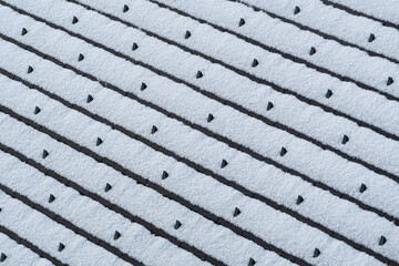 Snow covering roof tiles creating abstract winter pattern